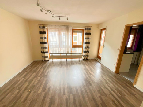 Wohnzimmer mit Zugang zur Küche und Balkon