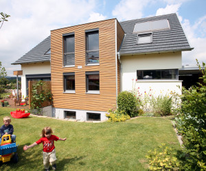 Einfamilienhaus mit spielenden Kindern im Garten