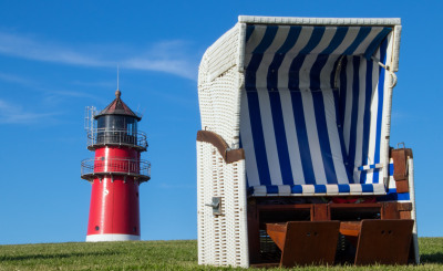 Strandkorb mit Leuchtturm im Hintergrund