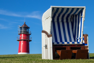 Strandkorb mit Leuchtturm im Hintergrund