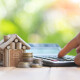 Modellhaus mit Taschenrechner und Unteralgen für den Immobilienverkauf