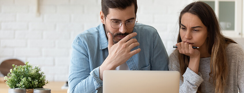 Paar informiert sich am Laptop über die Fehler beim Immobilienkauf