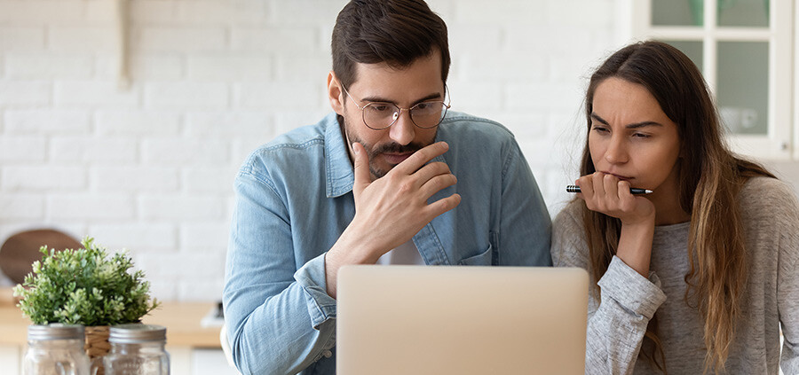 Paar informiert sich am Laptop über die Fehler beim Immobilienkauf