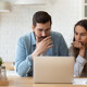 Paar informiert sich am Laptop über die Fehler beim Immobilienkauf