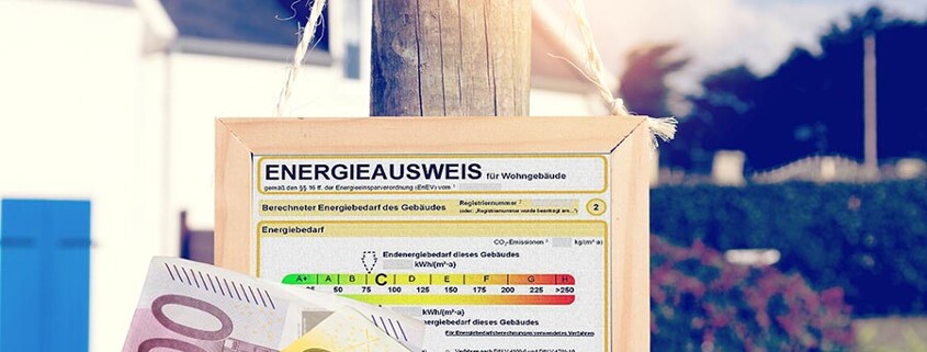 Energieausweis hängt an einem Holzpfosten, im Vordergrund zwei Geldscheine