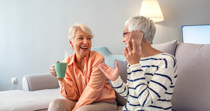 Zwei ältere Damen sitzen auf einer Couch in einer altersgerechten Neubauwohnung