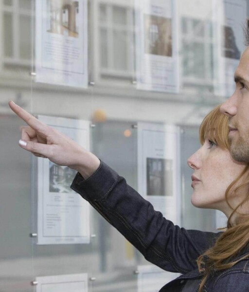 Paar vor Immobilienschaufenster
