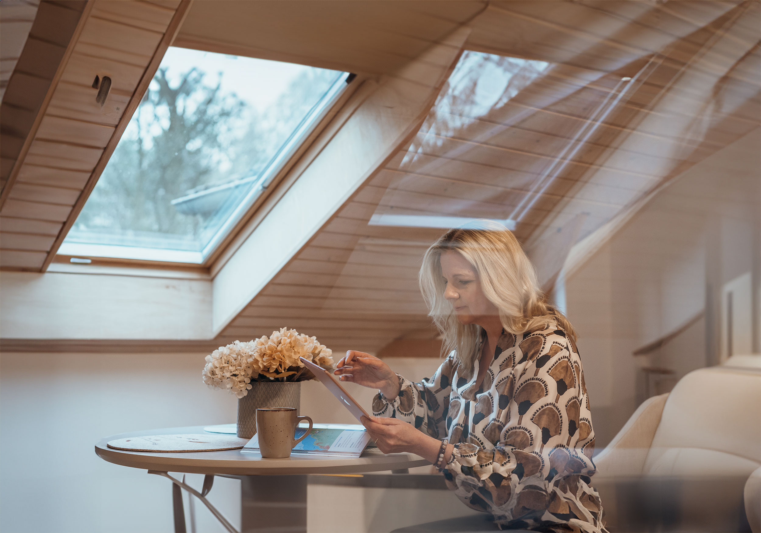 Immobilienmaklerin in ihrem Büro, konzentriert bei der Arbeit am Schreibtisch, helles Büro.