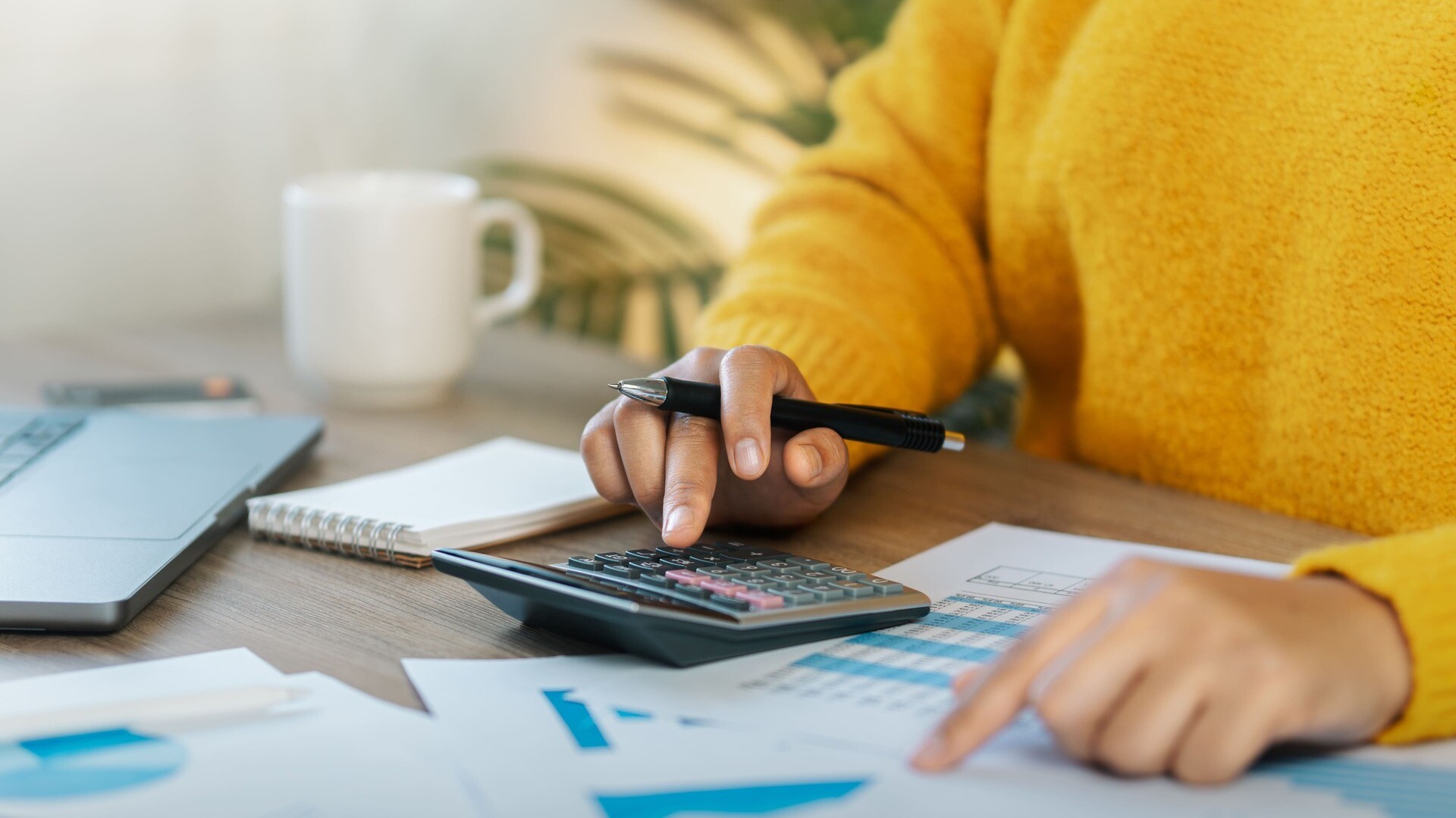 Eine Frau berechnet die Nebenkosten für ihre Immobilie