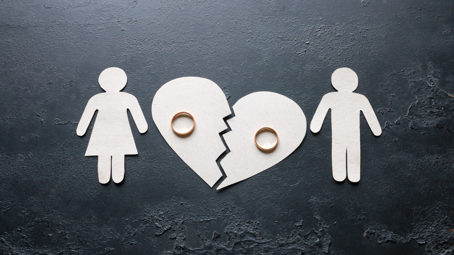 Scherenschnitte von Frau, Mann und zerbrochenem Herz mit Ringen.