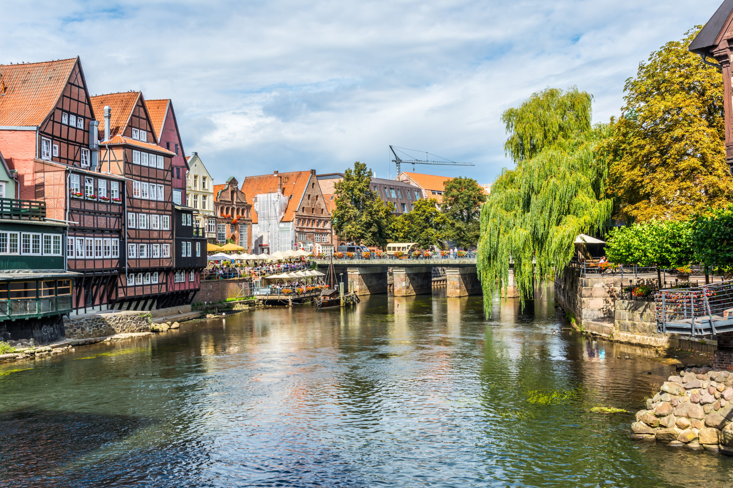 Der Fluss fließt an Fachwerkhäusern und einer Brücke vorbei.