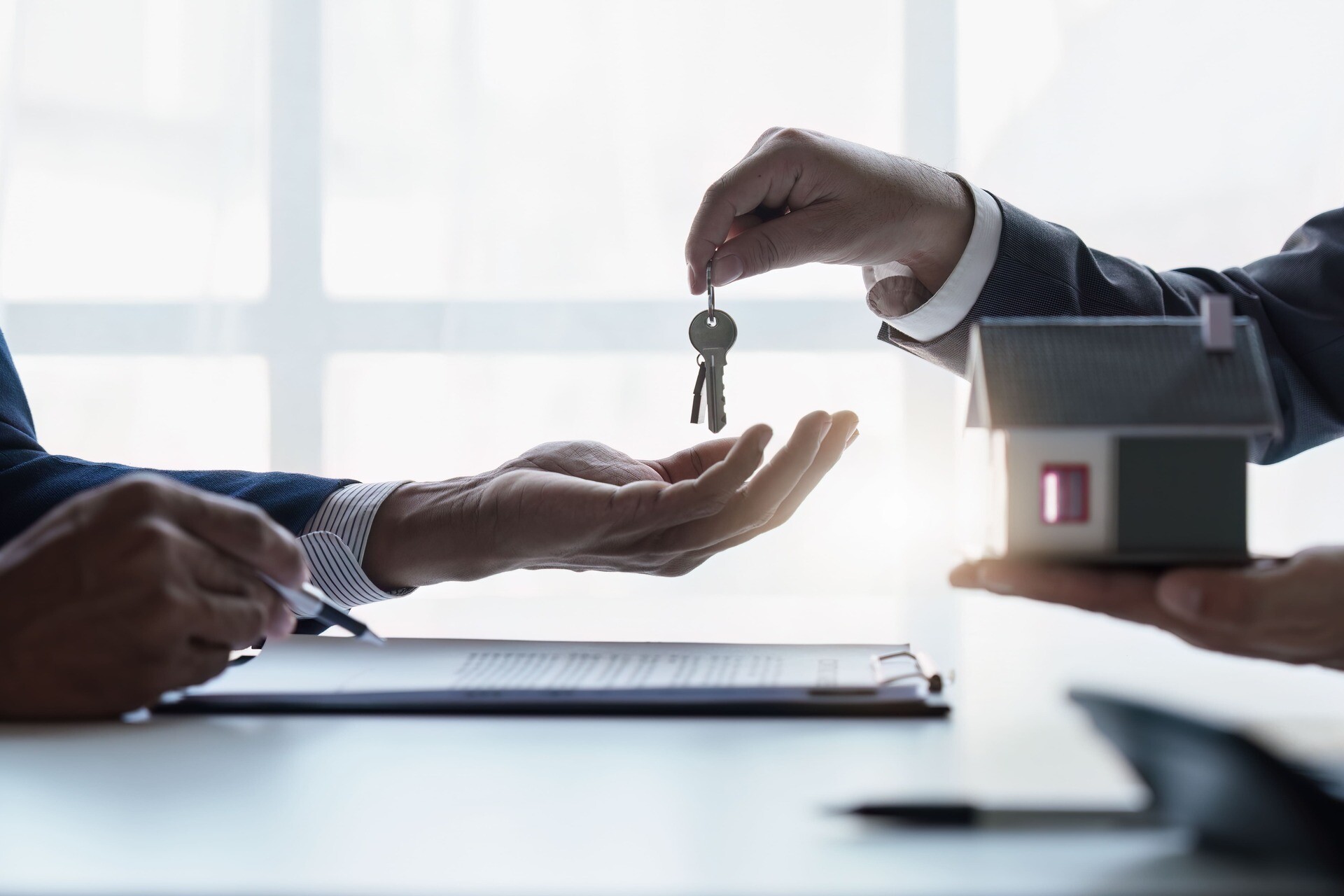 Nahaufnahme eines Immobilienmaklers, der Häuser und Grundstücke verkauft und Schlüssel sowie Häuser übergibt. Gespräch mit einem Immobilienmakler