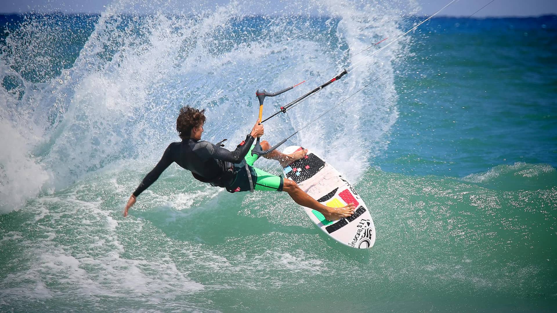 Kitesurfer dreht scharf und spritzt Wasser