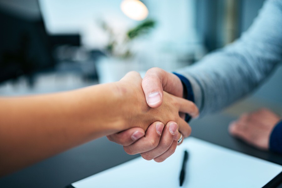 Eine Maklerin und ihre Kundin geben sich die Hand