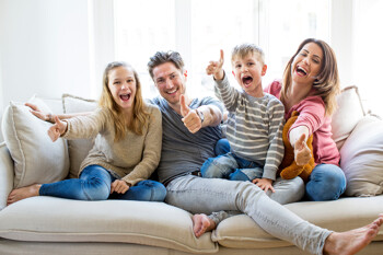 Glückliche Familie sitzt auf Sofa