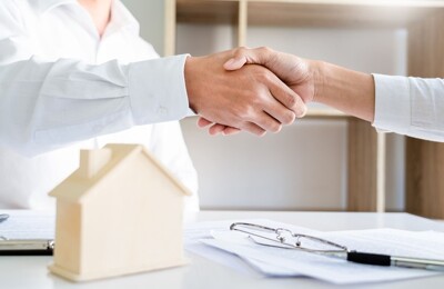 Ein Immobilienmakler gibt seinem Kunden die Hand