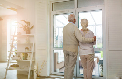 Älteres Ehepaar steht am Fenster