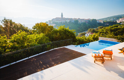 Terrasse und Pool einer Wohnung in Kroatien mit Ausblick auf die Stadt und das Meer