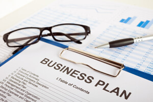 Business Plan mit Brille und Stift