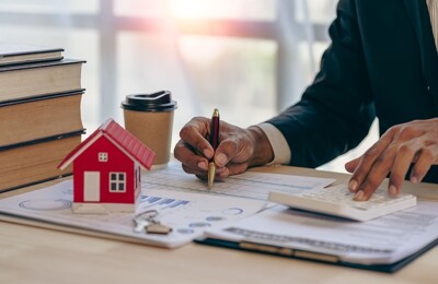 Ein Immobilienmakler bewertet eine Immobilie am Schreibtisch