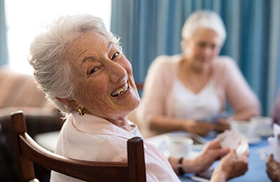 Lächelnde Seniorin spielt Karten