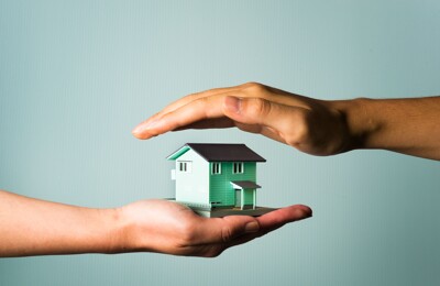 Modellhaus wird zwischen zwei Händen gehalten
