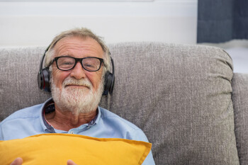 Mann mit Kopfhörern auf Sofa
