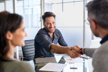 Männer schütteln sich im Büro die Hand