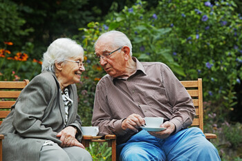 Älteres Ehepaar auf einer Bank im Garten