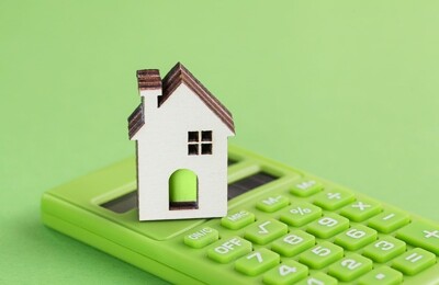 Modelhaus steht auf grünem Taschenrechner