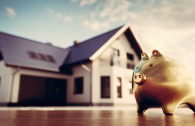 Goldenes Sparschwein vor einem Haus