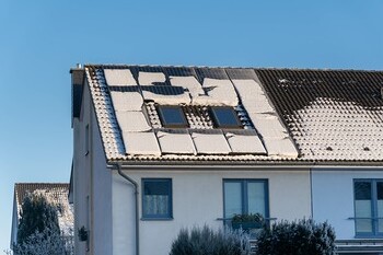 Hausdach mit Solaranlage im Winter
