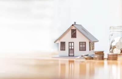 Ein Tisch mit Modellhaus und Münzen