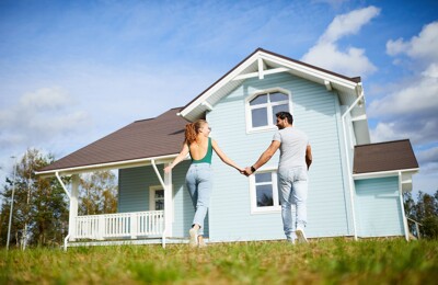 Glückliches Paar vor Ferienhaus