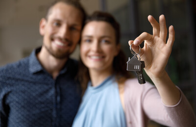 Glückliches Paar hält Schlüssel in den Händen