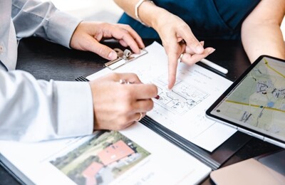 Makler betrachten Grundriss von Haus