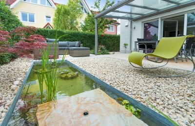 Eine Terrasse mit einem kleinen Teich
