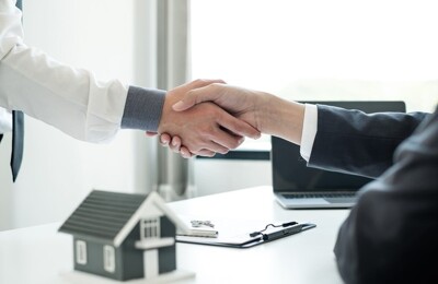 Ein Immobilienmakler und sein Kunde geben sich die Hand