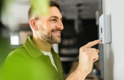 Mann bedient Heizung über Touchscreen