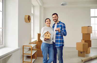Glückliches Paar mit Modellhaus und Schlüssel