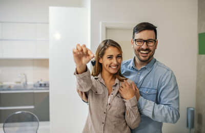 Glückliches Paar mit Schlüssel zum neuen Haus