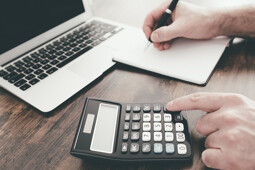 Makler mit Taschenrechner