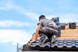 Ein Handwerker arbeitet auf dem Dach