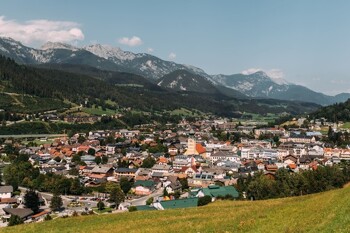 Der Dachstein ragt im Hintergrund einer Ortschaft auf