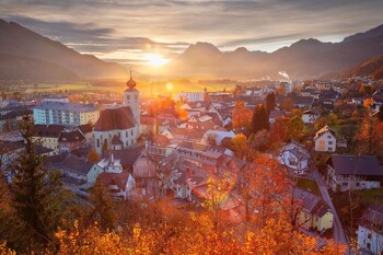 Sonnenuntergang über der Stadt Liezen mit Bergen im Hintergrund