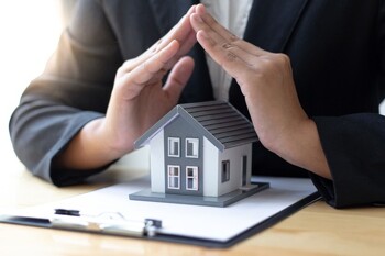 schützende Hände über Modellhaus