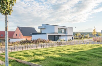 Ein modernes Einfamilienhaus in einer Wohnsiedlung im Grünen