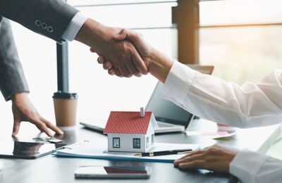 Ein Immobilienmakler und sein Kunde beim Handschlag