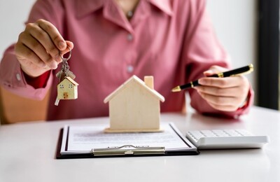 Ein Immobilienmakler übergibt den Schlüssel einer Immobilie