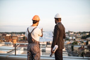 Bauarbeiter stehen auf Dach von Baustelle